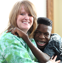 Karen wearing a green shirt hugs her son Moses