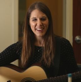 Neurologic Music Therapist, Laura Steines, holding a guitar